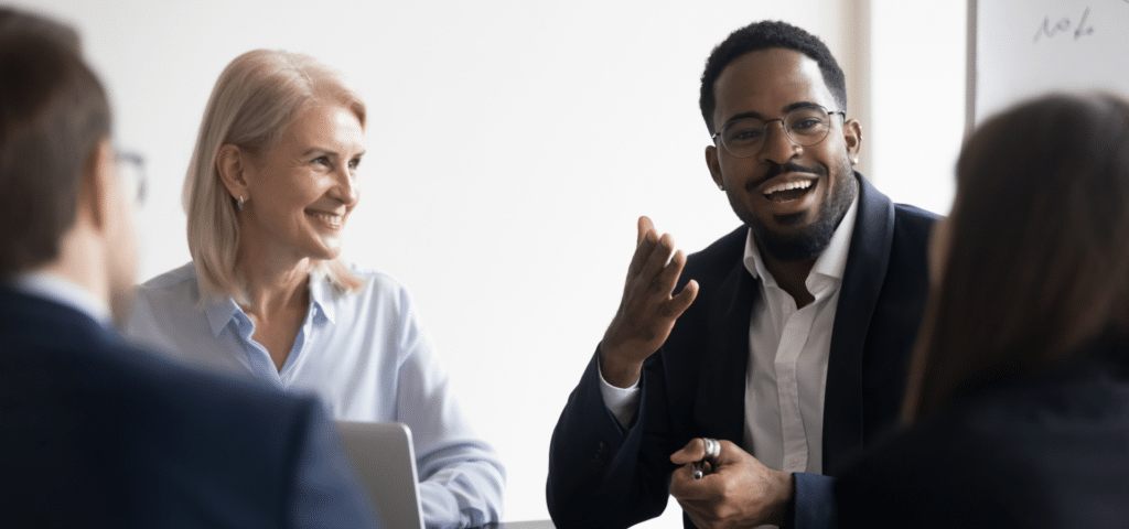 people talking at meeting table smiling