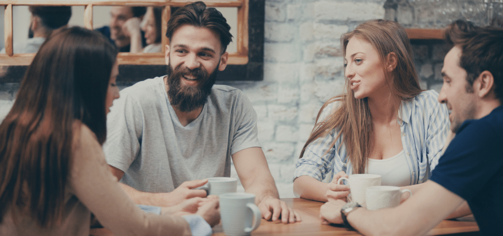 group of four young people talking over coffee